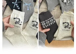 Detail of knitted mid-calf socks featuring cute puppy patterns and bow embroidery
