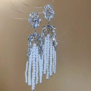 Detailed view of luxury silver flower earrings with crystal clusters and pearl tassels