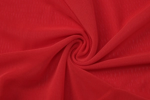 Macro détaillée de la texture du tissu en maille rouge respirante et des plis du textile