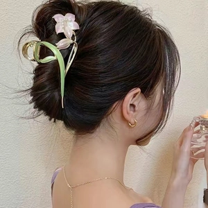 Elegant flower hair claw clip with green leaves and pink pearls on a female model