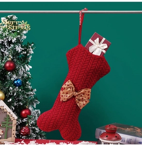 Detail view of red cable knit bone-shaped Christmas stocking with a brown polka dot bow