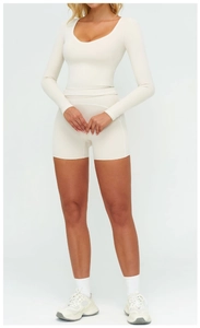 Détail du haut de sport crème à manches longues et du short de yoga taille haute cousu