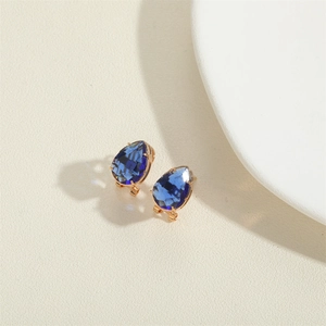 Elegant gold pear-shaped earrings featuring deep blue teardrop crystals in a minimalist style