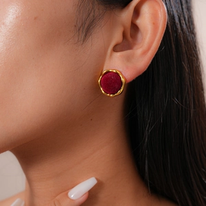 Close-up of vintage red flocked round earrings with gold wavy frames on model