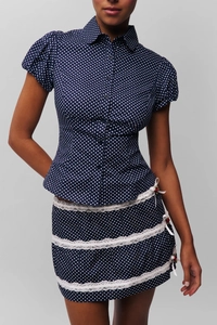 Detail of navy blue polka dot puff sleeve blouse with white lace trim skirt set