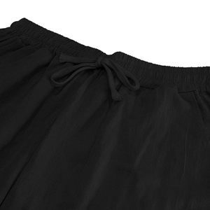 Detail of elastic waistband and braided drawstring on black cotton linen pants