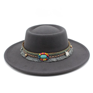 Détail du chapeau en feutre gris avec bande de perles turquoise et pompons bohèmes