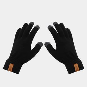 Detail of black knitted gloves featuring touchscreen fingertips and vintage leather patch