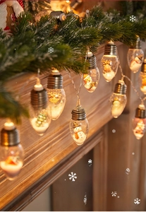 Close-up of LED Christmas wishing ball lights with miniature Santa and snowman inside