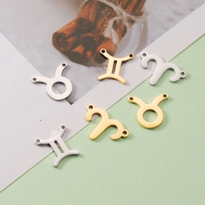 Macro view of gold and silver zodiac pendants in Taurus, Gemini, and Aries designs