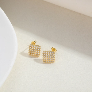 Macro view of gold-plated square stud earrings featuring micro-paved cubic zirconia stones