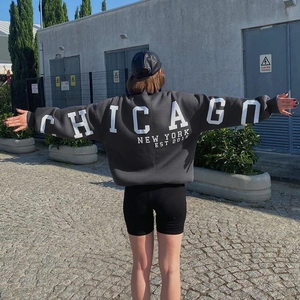 Détail d'un sweat-shirt gris foncé surdimensionné avec imprimé Chicago blanc au dos