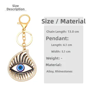 Detail showing blue evil eye teardrop keychain with white crystals and gold plating