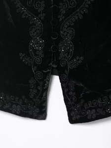 Macro view of black velvet vest featuring detailed sequin embroidery and resin buttons