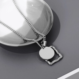 Detail shot of minimalist silver titanium necklace with geometric square and round pendant