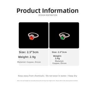 Detail of copper rings with oval red and green zircons and pavé settings on black background