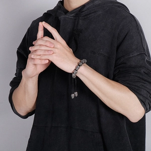 Male model wearing vintage skull charm bracelet with adjustable black braided rope