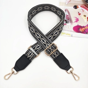 Detail of colorful jacquard wide strap with gold hardware and black leather ends
