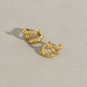 Macro view of gold irregular wave ear cuffs with high-polished stainless steel finish
