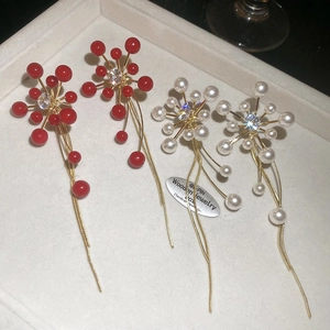 Macro view of crystal flower earrings with long gold tassels and hanging pearls