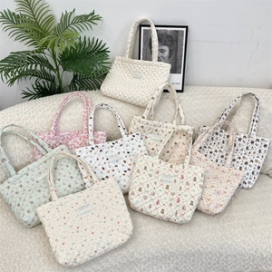 Detailed macro view of quilted cotton tote bags with assorted cute cartoon and floral prints