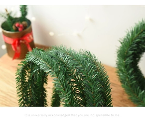 Macro shot of 5.5m dense green Christmas pine garland with realistic PVC needle texture