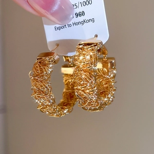 Detailed view of gold-plated woven texture hoop earrings on a display card