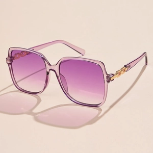 Detail of square oversized sunglasses with purple gradient lenses and gold chain temples