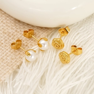 Élégantes boucles d'oreilles roses dorées et perles blanches sur fond texturé doux