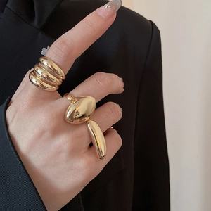Detailed view of three-piece irregular gold-plated bean rings set with glossy finish