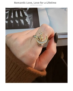 Detailed view of rotating star and moon ring with rhinestones in gold and silver finish