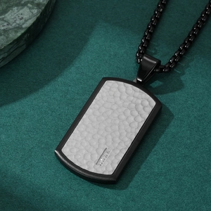 Men's two-tone hammered rectangular pendant necklace with black chain on dark texture