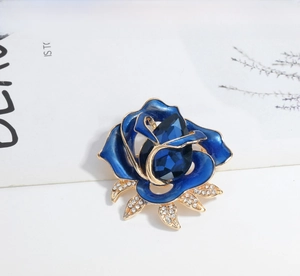 Macro detail of elegant blue rose brooch with enamel petals and crystal gemstone