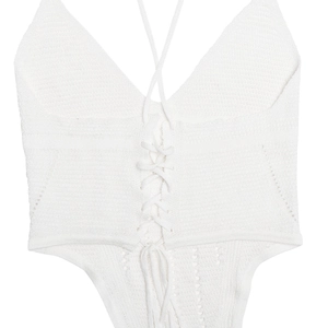 Gros plan détaillé du haut de bikini en tricot blanc montrant les liens et la texture tissée