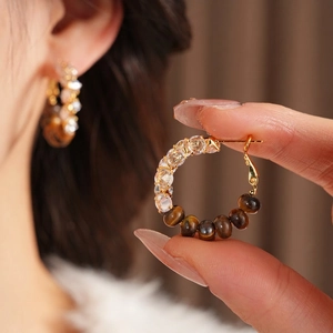 Golden C-shaped earrings with tiger eye and zircon beads in a high-end luxury design