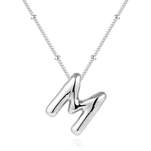 Detailed macro shot of silver bubble letter M pendant on a matching bead chain necklace