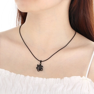 Gros plan d'un collier de projection patte noire porté par un mannequin en blanc