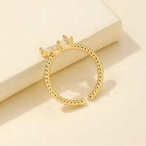 Golden twist open ring for women with dual baguette cut cubic zirconia in a four-prong setting