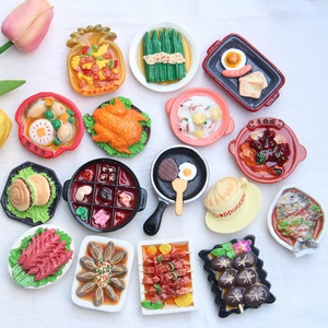 Detailed view of hyper-realistic miniature resin food models on white textured fabric