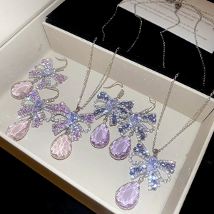Detailed macro view of pear-cut zircon butterfly pendant necklace and matching earrings