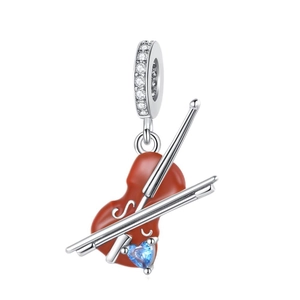 Detail view of heart music charm with red enamel and blue gemstone inlay
