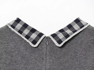 Close-up of grey knit dress featuring a plaid Peter Pan collar and hidden back zipper