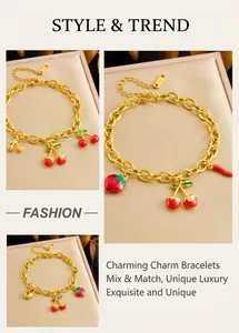 Detail of gold-plated chain bracelet with red cherry, strawberry, and heart charms