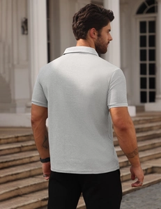 Rear view of light grey waffle texture men's polo shirt worn by a model in outdoor setting