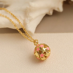 Golden necklace featuring a sphere pendant with hollow stars and pink enamel finish