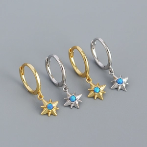 Macro detail of 925 silver starburst drop earrings with blue opal stone in gold and silver