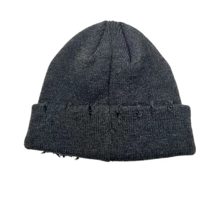 Detailed view of dark grey knitted beanie featuring trendy distressed ripped edge style