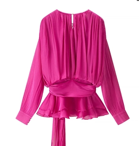 Detailed view of magenta satin long sleeve top with waist pleats and ruffled hem accents