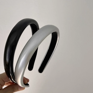 Detail showing wide black and silver faux leather headbands with smooth glossy finish