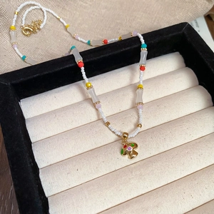 Detail of colorful beaded necklace with a mushroom pendant on a velvet jewelry box